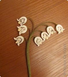 four white flowers sitting on top of a wooden table