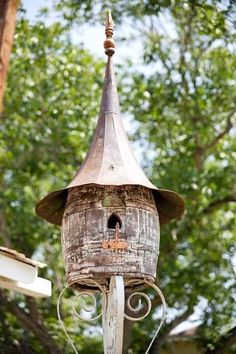 an old bird house is hanging from a pole