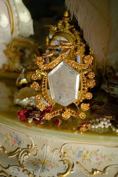 an ornately decorated table with gold and white decorations on it's sides, including a clock