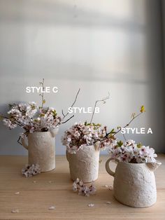 three vases with flowers in them sitting on a table