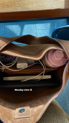 the inside of a purse with items in it sitting on a chair next to a table