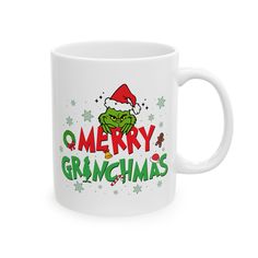 a white coffee mug with the words merry grinmas on it