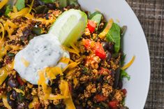 a white bowl filled with taco salad topped with sour cream