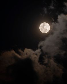 the full moon is shining brightly in the dark night sky with some clouds around it