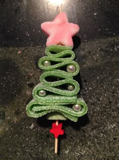 a christmas tree made out of green felt on a toothpick with a pink star