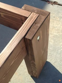 a wooden bench sitting on top of a sidewalk