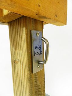 a dog hook on the side of a wooden post with a sign that says dog hook