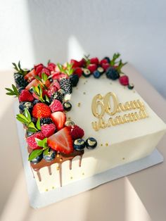 a birthday cake with strawberries and berries on it