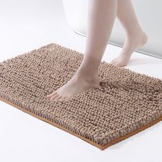 a person standing on top of a bathroom rug