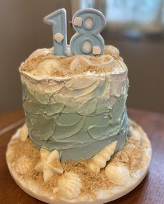 a blue and white frosted birthday cake with the number eighteen on it's top