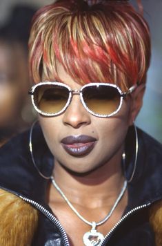 a close up of a person wearing sunglasses with red hair and piercings on their ears