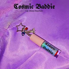 A customized mini lip gloss with a keychain featuring cosmic charms. Cool accessory to hang on your favorite purse to showcase your love for space exploration. #12 Color: Rocket Fire Red Keychain style: Rocket, Alien, Rhinestone charms with 'Cosmic Baddie' logo. This liquid lipstick has a matte finish and becomes waterproof on your lips. Once it dries, it is kiss-proof, smudge-proof, and stays on your lips for hours, providing you with the confidence of a baddie. This accessory was created for A Baddie Lipgloss, Lip Gloss Keychain, Mini Lip Gloss, Red Keychain, Favorite Purse, Red Fire, Space Exploration, Liquid Lipstick, Rocket