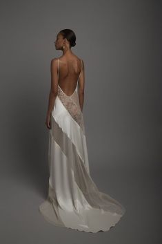 the back of a woman wearing a white dress with sheer fabric and an open back