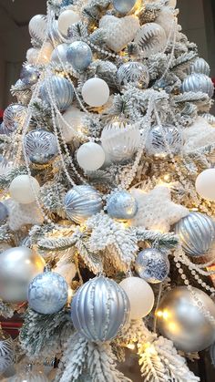 a christmas tree decorated with silver and white ornaments