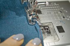 someone using a sewing machine to sew something on the side of a piece of fabric