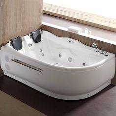 a white bath tub sitting on top of a floor next to a window with blinds