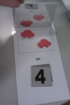 the number four is placed on top of an envelope with red paper cut out to look like elephants