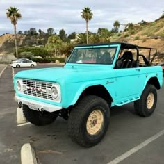 an old blue truck parked in a parking lot