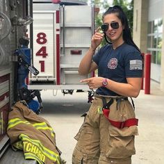 a woman standing next to a fire truck