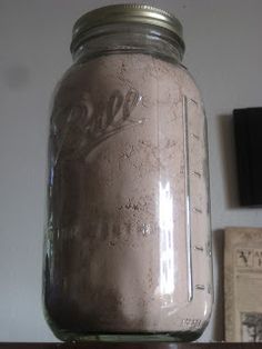 a mason jar sitting on top of a wooden shelf next to a wall mounted clock