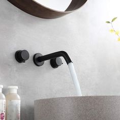 a bathroom sink with a black faucet and soap dispenser next to it