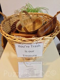 a basket with some wooden spoons in it on a table next to a sign that says, you're trash is our treasure