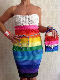 a woman in a rainbow colored dress holding a purse