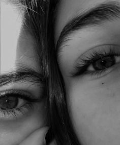 two people with long eyelashes are looking at the camera and one person has their face close to the camera