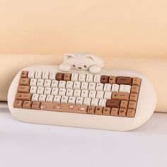 a white and brown computer keyboard sitting on top of a table