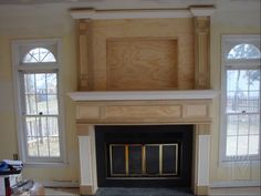 an empty living room with a fireplace and windows