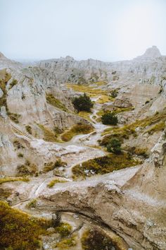 an aerial view of a rocky landscape with trees in the foreground and mountains in the background