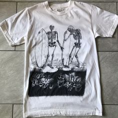 Organic Cotton Never Worn Surfing Skeletons T-Shirt Small By La Based Clean Aesthetics . Made In The Usa. Off White Color. Never Worn, Tags Removed. Summer Band Merch T-shirt With Back Print, White Vsco T-shirt With Text Print, Summer Crew Neck Top With Back Print, Summer Streetwear Tops With Back Print, Fitted Cotton T-shirt For Beach, Spring Vsco Streetwear Tops, Summer Band Merch Shirt With Screen Print, Band Merch Screen Print Shirt For Summer, Band Merch Shirt With Screen Print For Summer