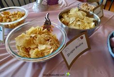 three bowls filled with chips sitting on top of a pink table cloth covered tablecloth