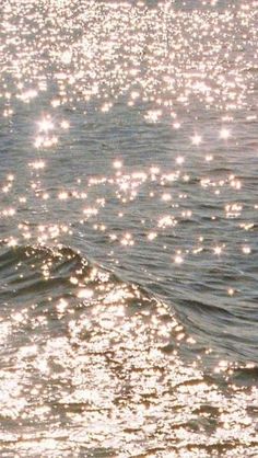 a person riding a surfboard on top of a wave in the ocean at sunset