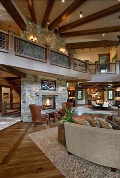 a living room with couches, chairs and a fire place in the middle of it