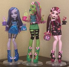 three monster high school dolls are standing on the table with cups and saucers in their hands