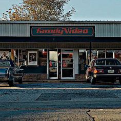 two cars parked in front of a family video store