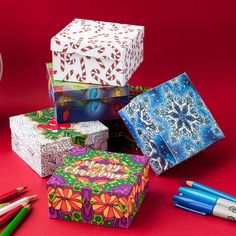 several colorful boxes and pencils on a red surface