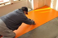 a man is working on an orange floor