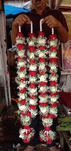 a man is holding up a bunch of flowers