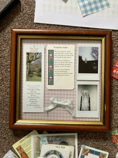 a wooden frame with pictures and cards in it on the floor next to other items