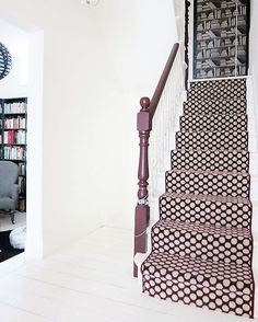 the stairs are decorated with black and white designs, along with bookshelves on either side