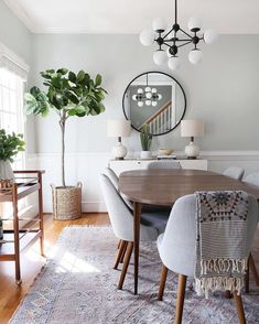 a dining room table with chairs and a mirror on the wall in front of it