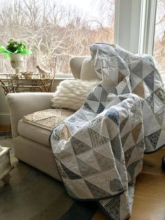 a couch with a blanket on it next to a window