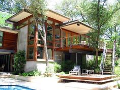 a house with a pool in front of it and stairs leading up to the upper level