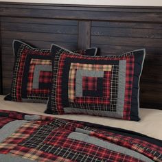 a bed topped with pillows and blankets next to a wooden headboard