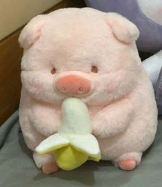 a pink stuffed animal with a banana in its mouth