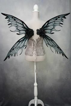 a white mannequin with black wings on it