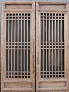 two wooden doors with bars on each side