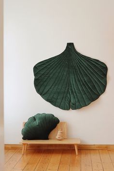 a green scallop shell hanging on the wall next to a wooden bench